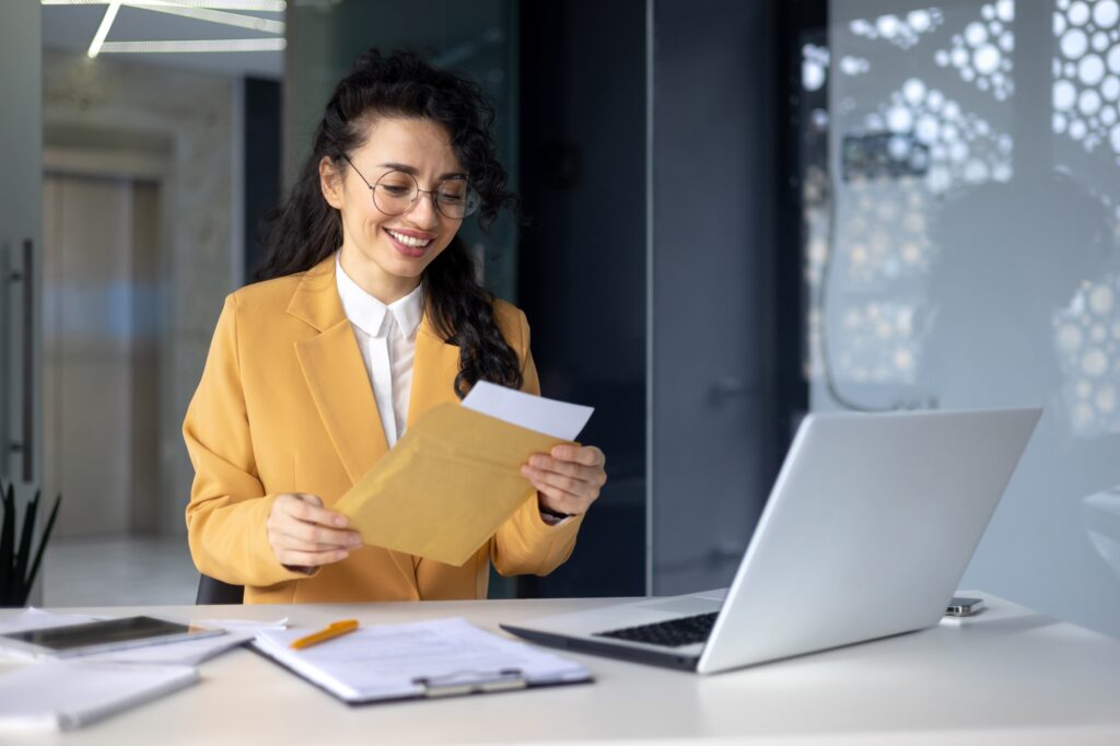 Successful hispanic woman inside office at work businesswoman received postal envelope letter
